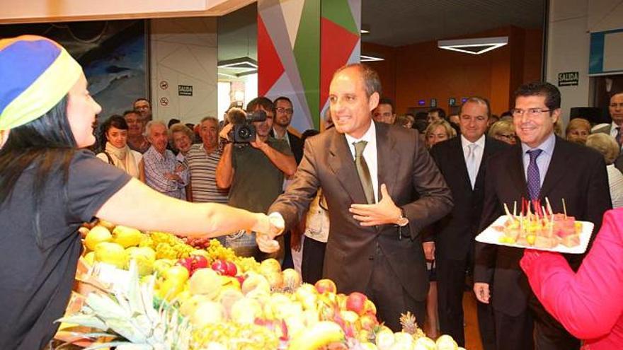 Camps, con Ripoll y Pérez Fenoll, saluda a la dependienta de un puesto de fruta tras inaugurar el nuevo Mercado Municipal