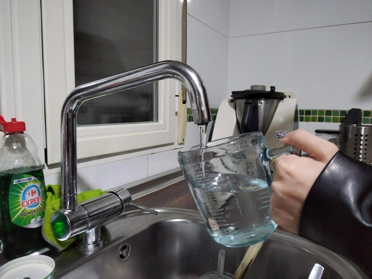 Una persona llenando una jarra de agua del grifo en Plasencia.