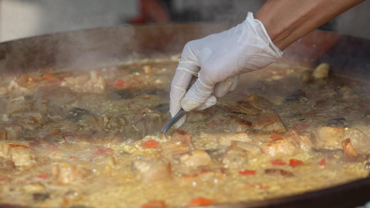Un cocinero prepara una paella.