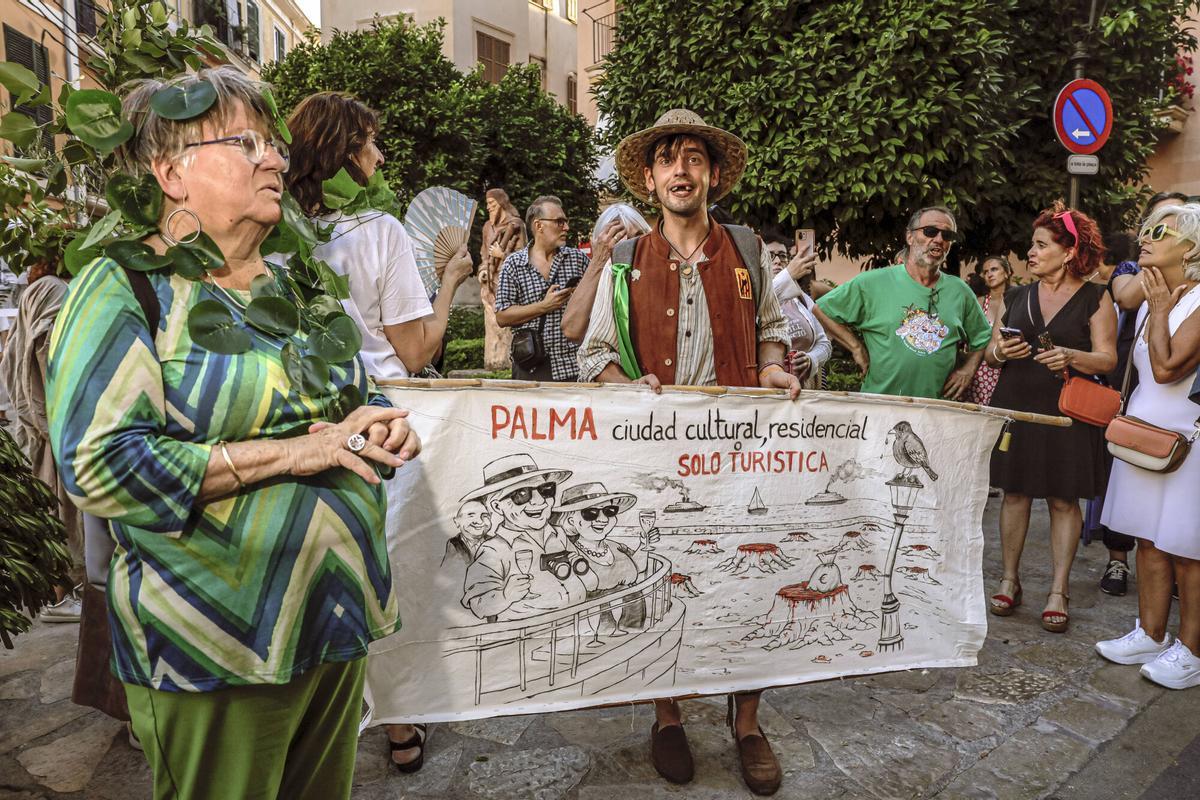 Vecinos de la Calatrava y Canamunt, muchos vestidos de verde y con ramas de árboles, se unen durante sus cercavilas para homenajear a los bellasombras talados en la plaza Llorenç Villalonga.