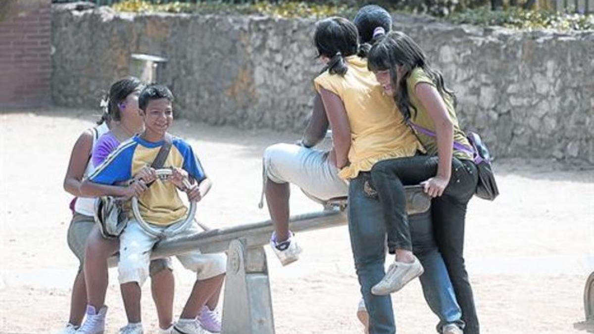 Unos menores hijos de inmigrantes, en una zona de juego de un parque de Barcelona.