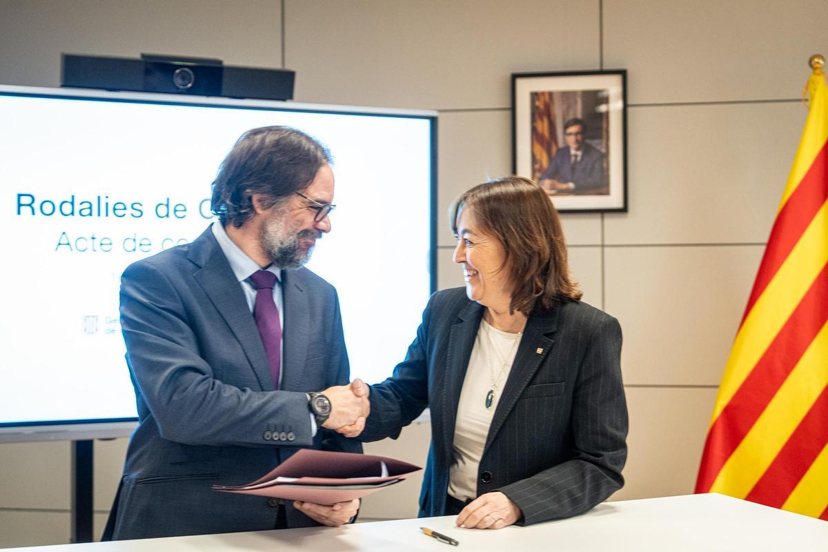 La consellera Sílvia Paneque y el presidente de Renfe se dan la mano tras la firma de la constitución de la empresa Rodalies de Catalunya.