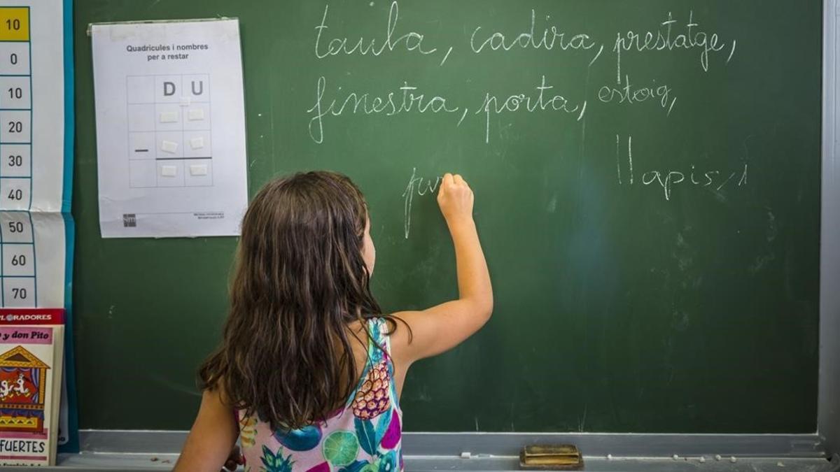 Una niña escribe en la pizarra, en una clase del colegio público Jaime Balmes, en València, el pasado julio.