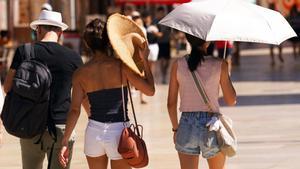 Unos turistas se protegen del sol en Málaga, el pasado día 12.
