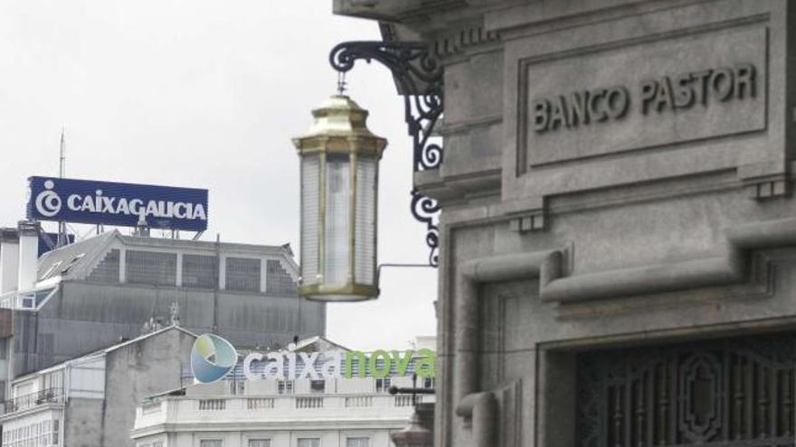 Fachada del Banco Pastor en A Coruña en primer plano con los logos de Caixanova y Caixa Galicia al fondo. / eduardo vicente