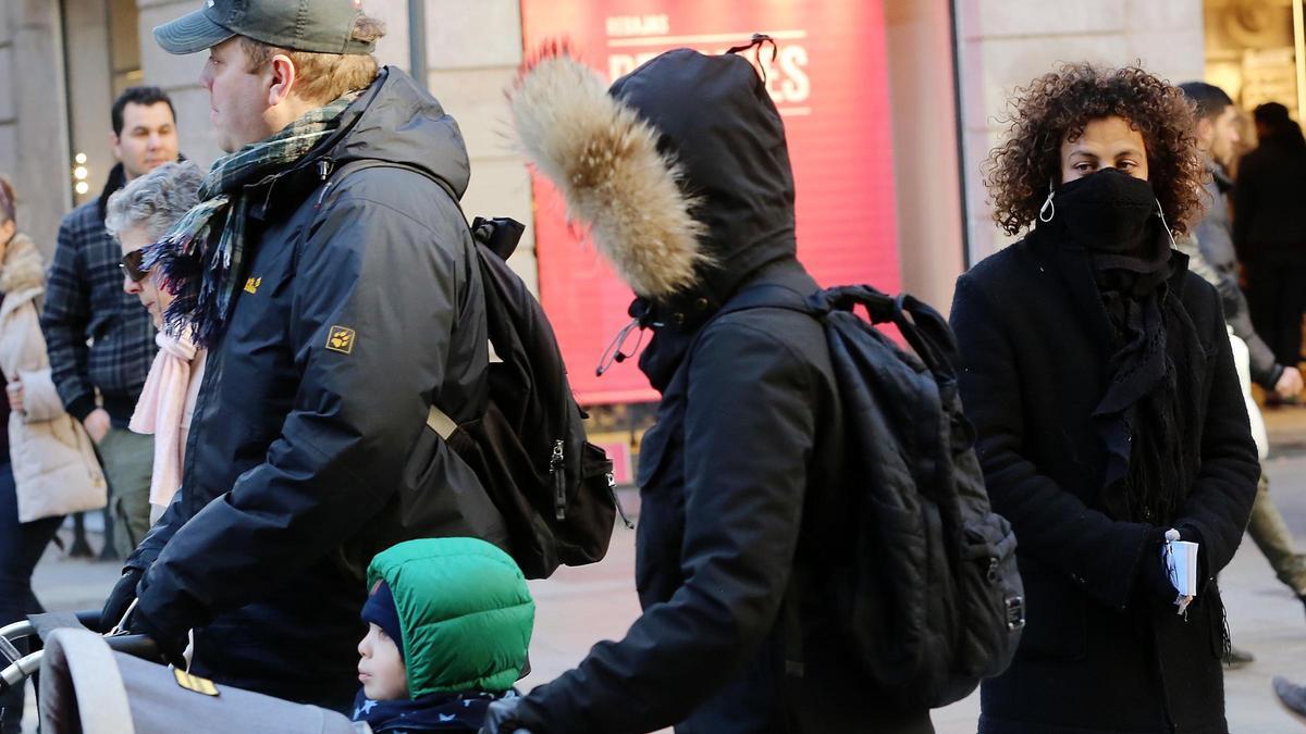 Personas se protegen del frío con abrigos, capuchas y bufandas