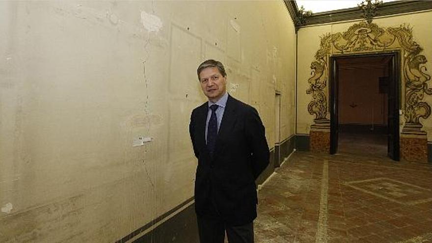 Vicente Genovés, en una de las salas del Colegio del Arte Mayor de la Seda donde se aprecian las grietas en la pared.