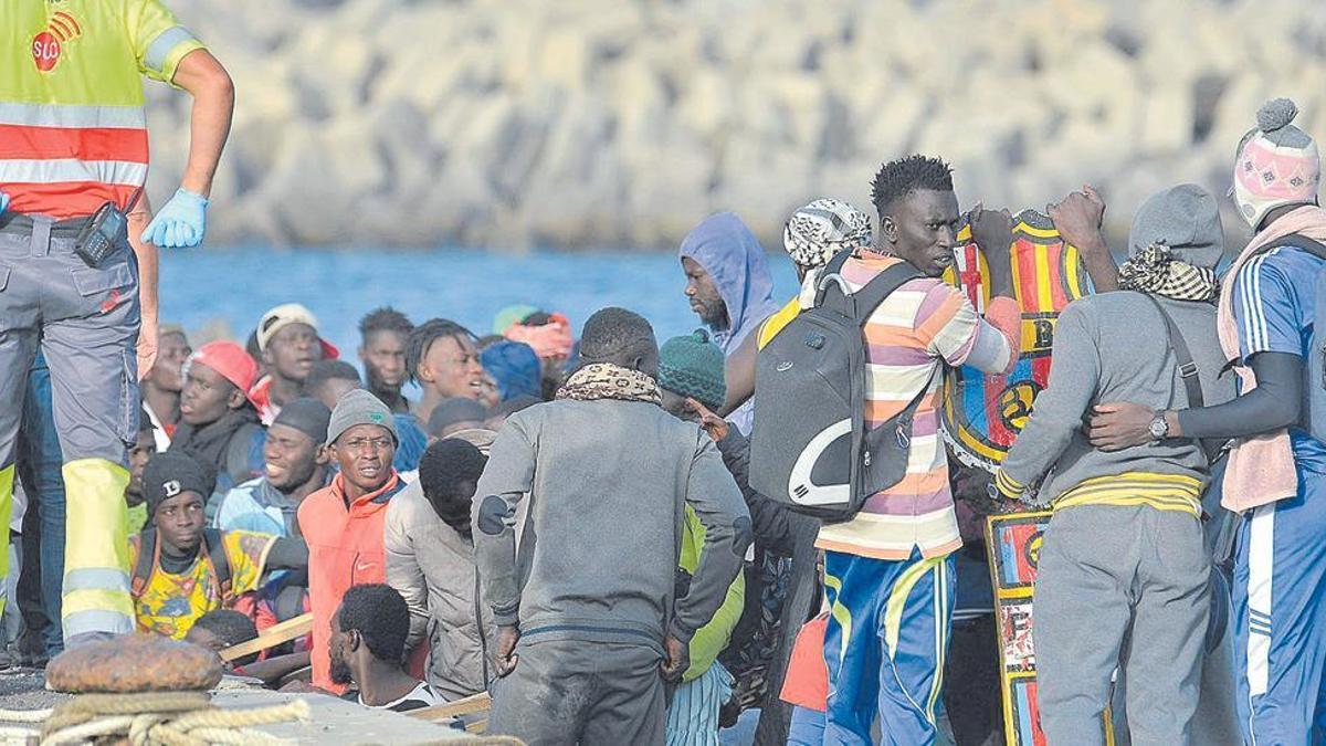 Migrantes esperan para desembarcar del cayuco en el puerto herreño de La Restinga.