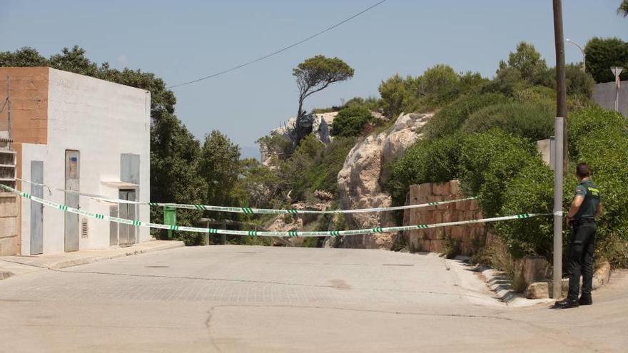 Un guardia civil ayer en la carretera precintada que da acceso a la zona donde apareció el cadáver.