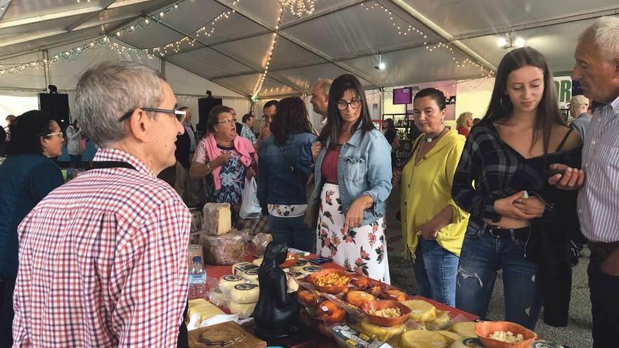 Asistentes a la feria, en el stand del queso de Vidiago de Manuel Collera.