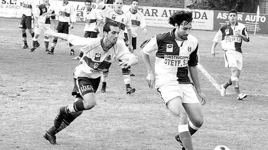 El jugador del Gijón Industrial Diego López, a la izquierda, presiona al arlequinado Manolo.