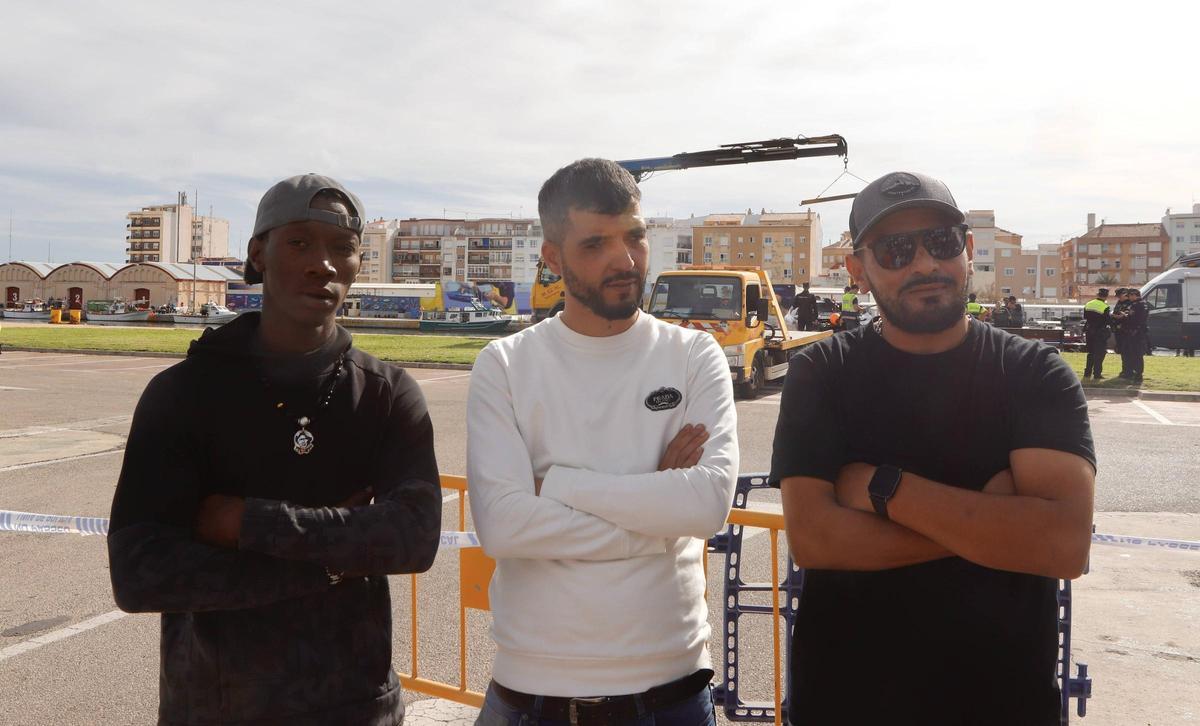 Tres de los rescatadores, la mañana del viernes, cuando esperaban a que se sacara el coche del puerto.