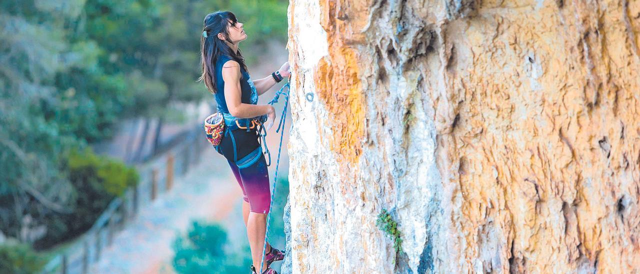 Una escaladora en la ascensión por la pared de La Cova de la  Petxina.