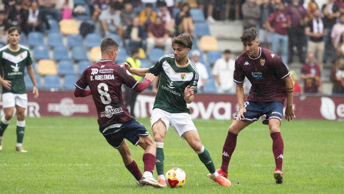 Ajenjo, entre dos jugadores del Pontevedra en la primera jornada de liga.