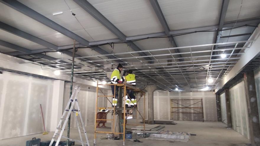 Dos personas realizando las labores de ejecución bajo cubierta de las gradas. | E. P.