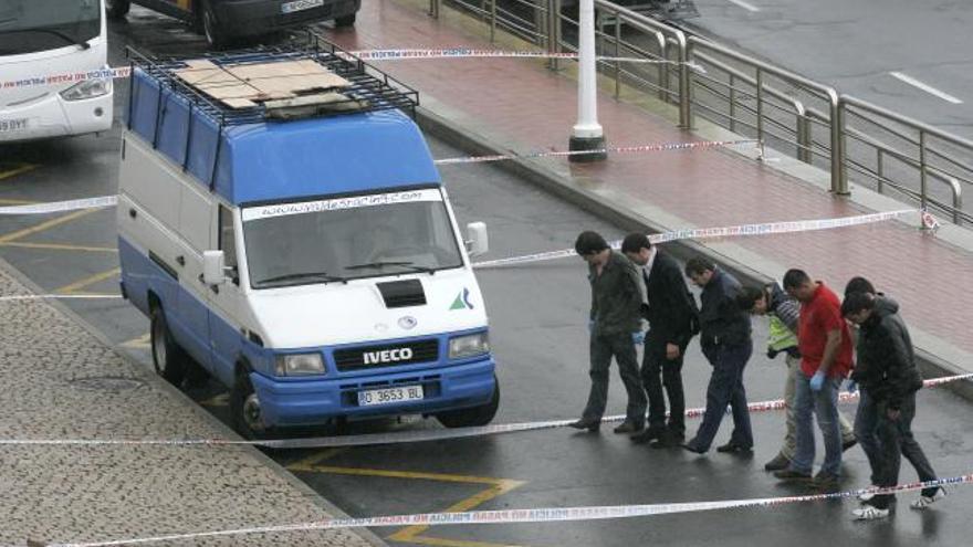 Agentes policiales buscan los casquillos en la zona donde tuvo lugar el tiroteo.  // Eduardo Vicente