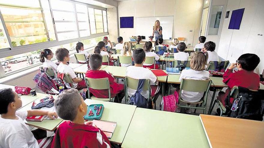 Un grupo de alumnos de tercero de Primaria, estrenando aula ayer con su profesora Inma. En su mesa luce la primera violeta de la clase.