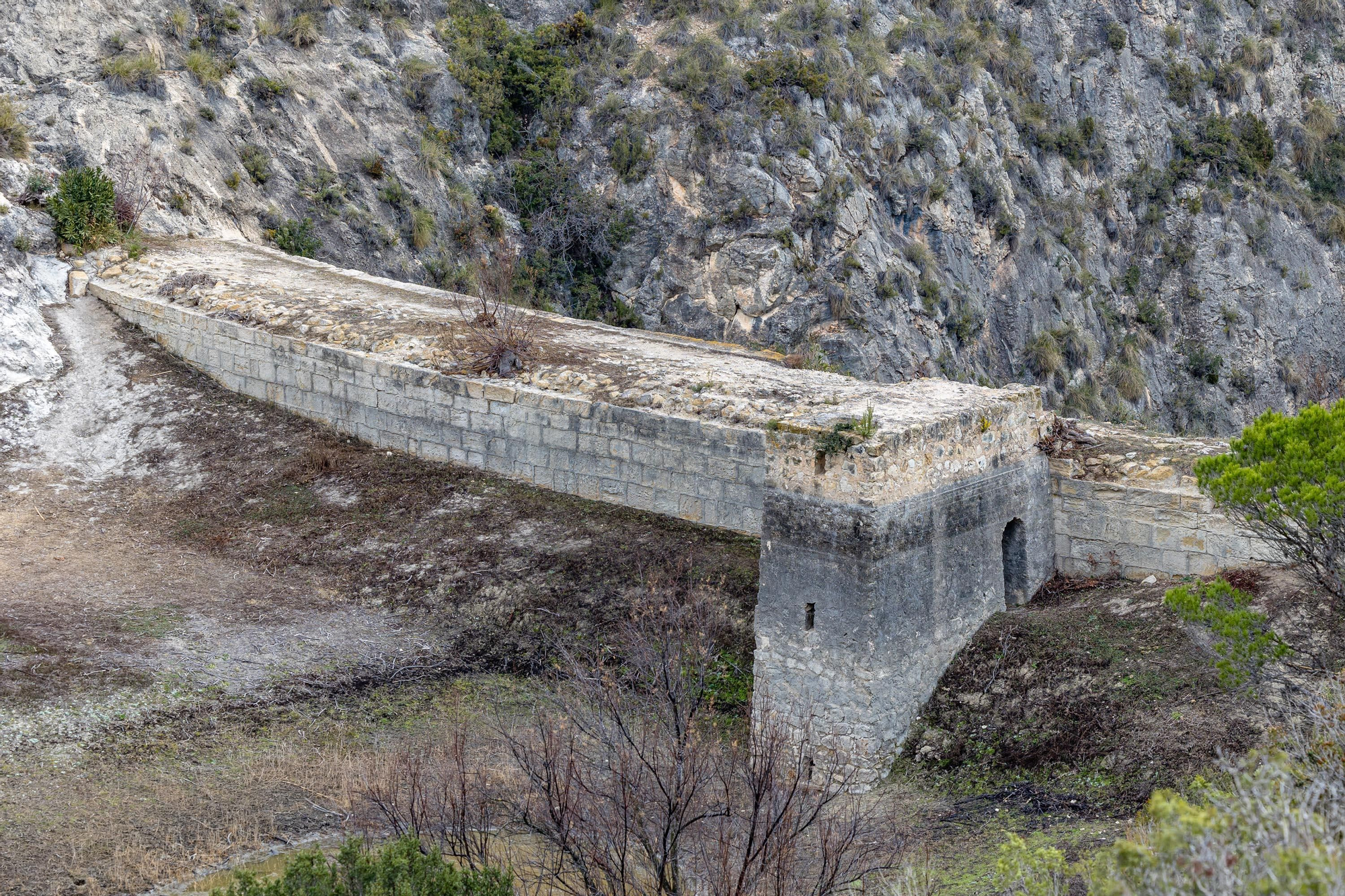 Una pasarela de madera de 212 metros anclada en la pared recorre la profunda garganta junto al antiguo pantano de Relleu