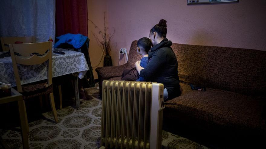 Una madre con su hijo calentándose con un radiador eléctrico. | Carlos Montanyes