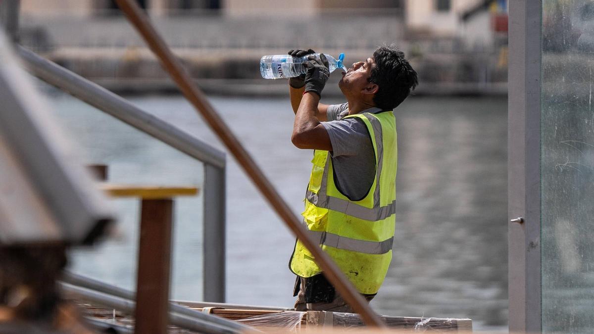 Un trabajador se refresca para sobrellevar el calor en Barcelona.