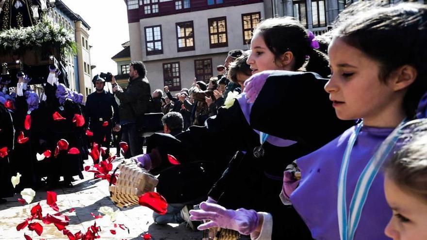 Los niños tiran pétalos a la Virgen de la Soledad a su llegada a la iglesia de San Isidoro.