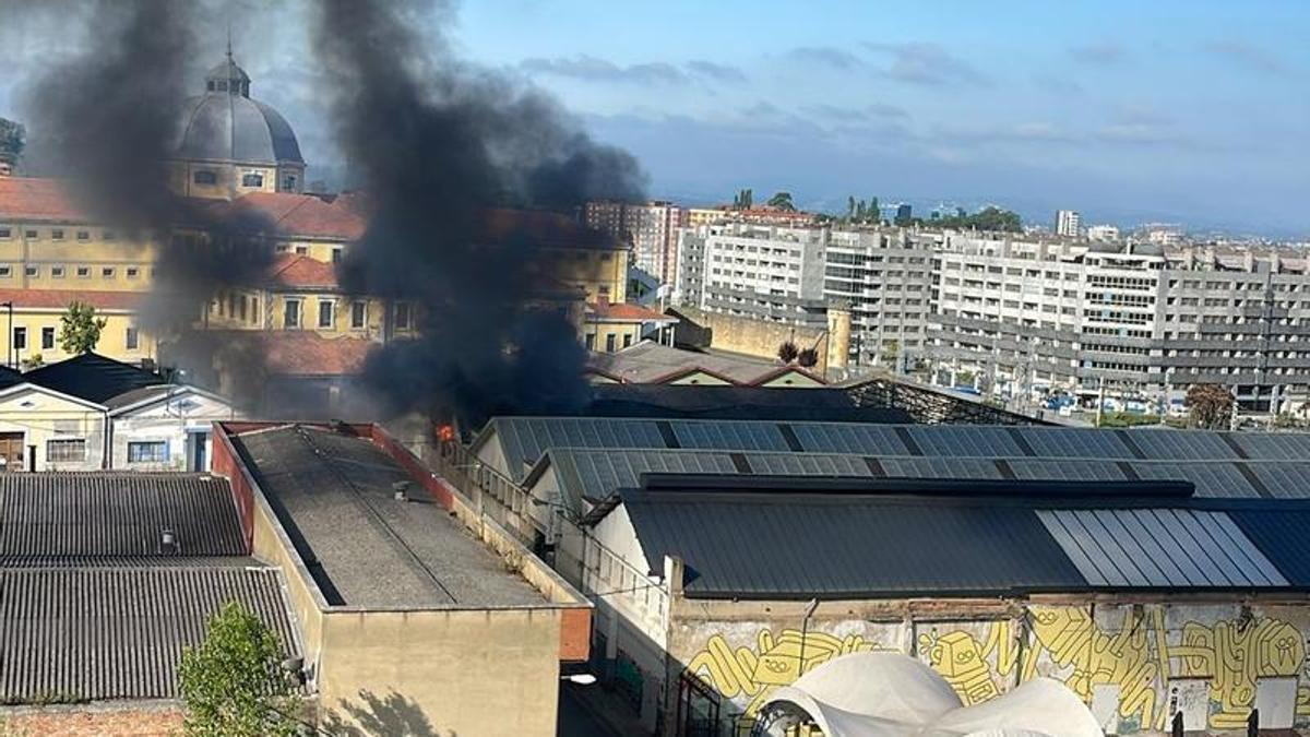 Una columna de humo negro saliendo de Almacenes Industriales.