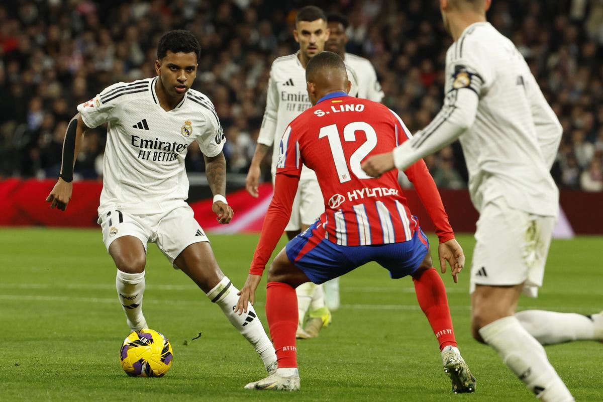 MADRID, 08/02/2025.- El delantero del Real Madrid Rodrygo Goes (i) pelea un balón con Samuel Lino, del Atlético, durante el partido de LaLiga de fútbol que Real Madrid y Atlético de Madrid disputan este sábado en el estadio Santiago Bernabéu. EFE/Chema Moya