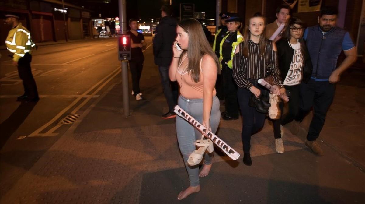 Asistentes al concierto de Ariana Grande salen tras la explosión en el Manchester Arena.