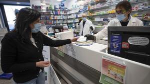 Rome (Italy), 09/04/2020.- A pharmacist hands a face mask to a customer, in Rome, Italy, 09 April 2020, during the coronavirus disease (COVID-19) pandemic. New provisions of face masks arrived to the pharmacies in the country to fight the coronavirus pandemic. (Italia, Roma) EFE/EPA/CLAUDIO PERI