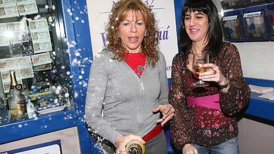 Julia Caride (izq.) y Eva Díaz descorchan la botella de champán para celebrar el quinto premio.