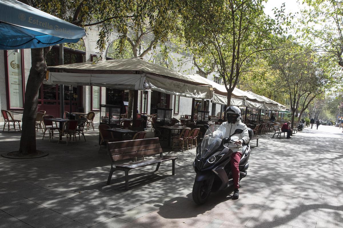 Una moto circula por la peatonal Enric Granados junto a una macroterraza, este miércoles.