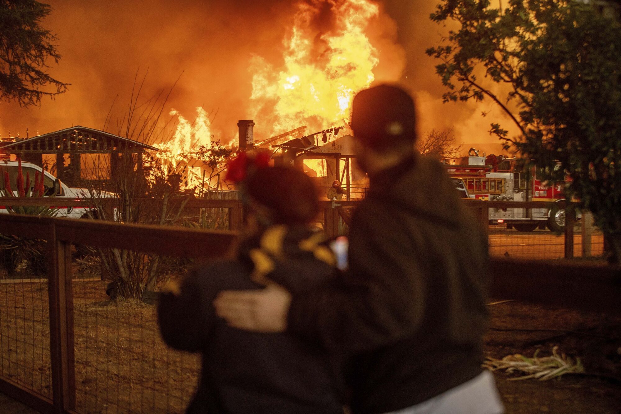 People watch as the Eaton Fire engulfs a structure Wednesday, Jan. 8, 2025, in Altadena, Calif. (AP Photo/Ethan Swope) Associated Press / LaPresse Only italy and Spain. EDITORIAL USE ONLY/ONLY ITALY AND SPAIN