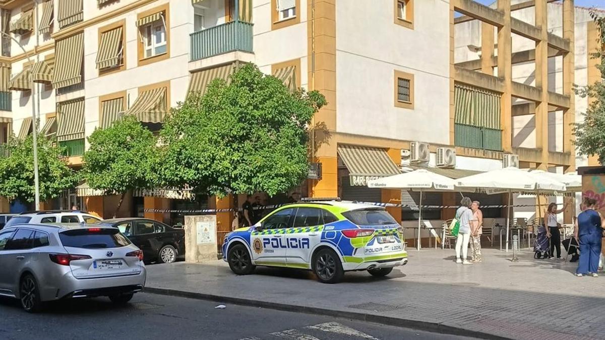 Un coche de policía ante el bar donde ha fallecido de un infarto un vecino del barrio del Guadalquivir en Córdoba, acordonado a la espera del levantamiento del cadáver, la mañana de este miércoles.