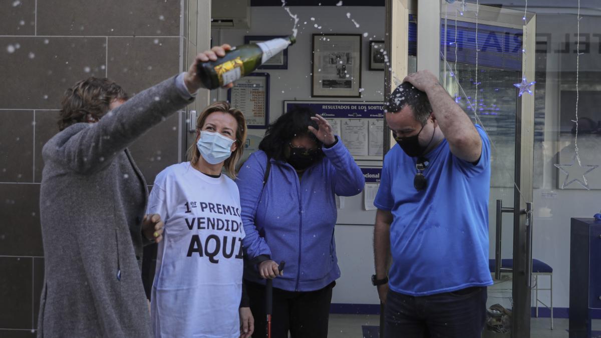 Una pareja de afortunados celebran el premio Gordo junto a las loteras en la administración de lotería situada en la Avenida de Andalucía en la que se ha repartido parte del número `72.897´ correspondiente a &#039;El Gordo&#039; .