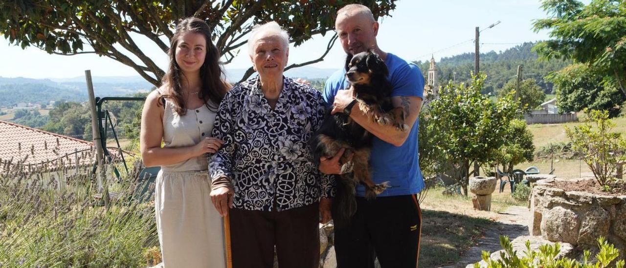 Amparo González, junto a su bisnieta y un nieto político en el jardín de su casa de Vilar.   // BERNABÉ