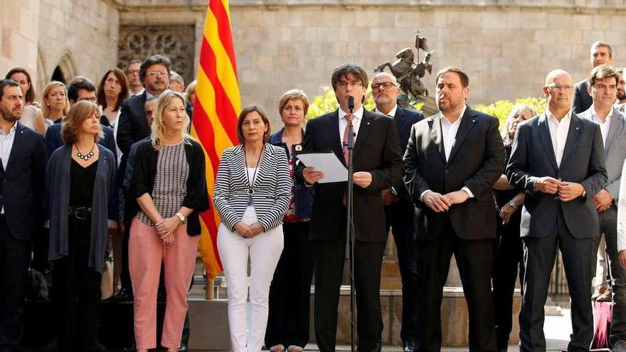 Puigdemont lee el texto del anuncio rodeado de diputados de Junts pel Sí. // Reuters
