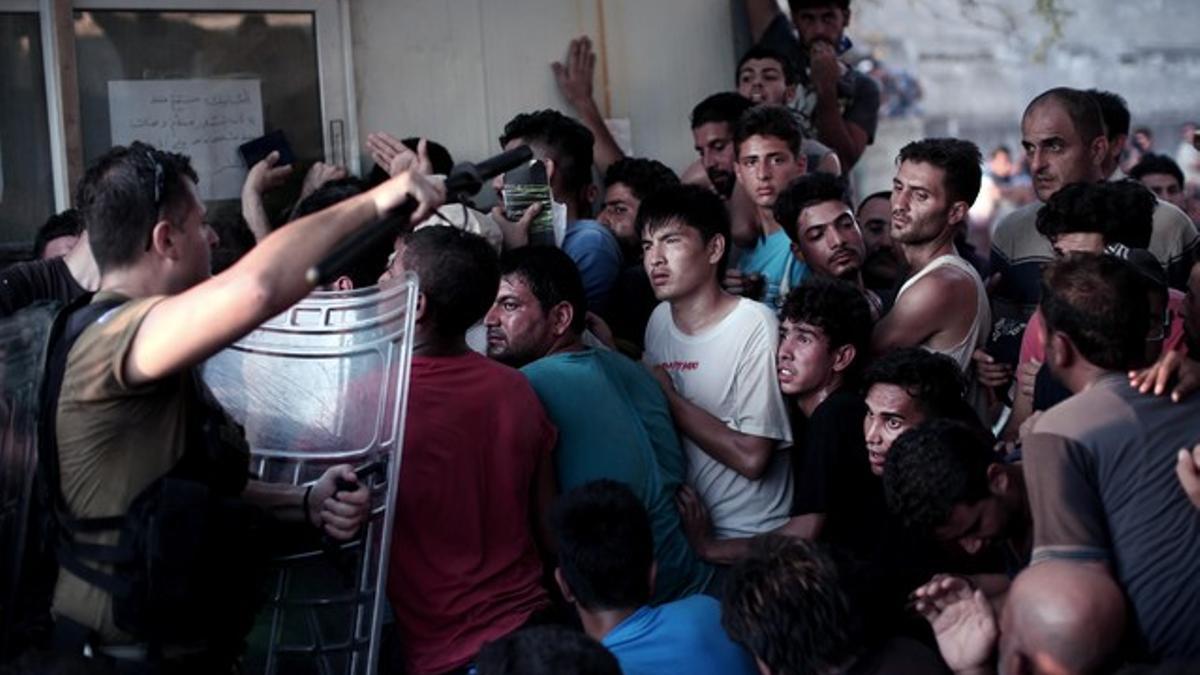 La policía helena carga contra los inmigrantes que esperan para registrarse en el puerto de Mitelene, en la isla de Lesbos.