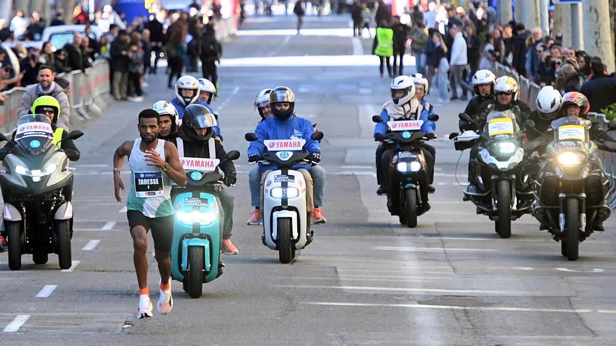 El suizo Abraham Tadesse perseguido por las motos de la organización a pocos metros de la meta de la maratón de Barcelona 2024.