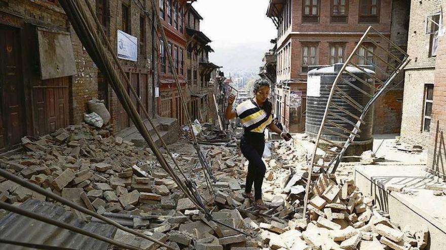 Una mujer camina entre los escombros en Bhaktapur (Nepal) un día después del terremoto.