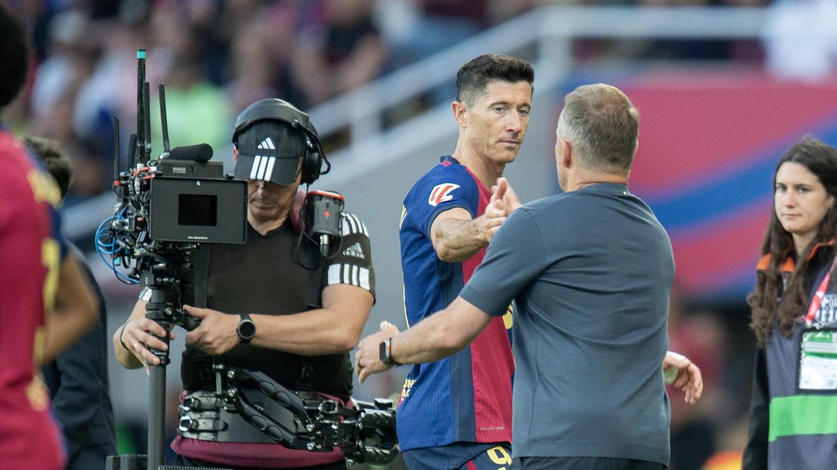 Un cámara de televisión filma a Hansi Flick felicitando a Lewandowski