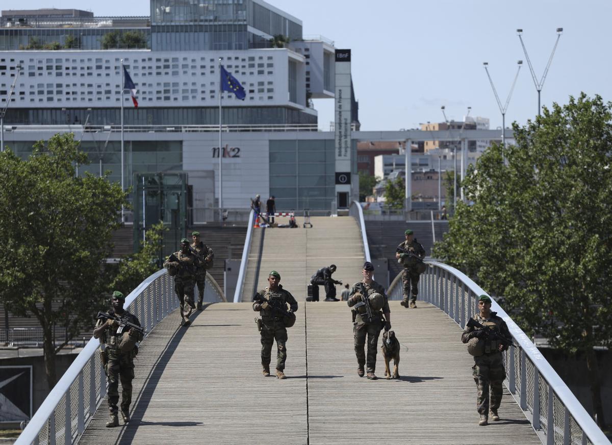 Soldiers patrol on a footbridge over the Seine river ,Wednesday, July 17, 2024 in Paris. Frances armed forces held a demonstration of the security measures planned on the River Seine, both in and out of the water, to make it safe for athletes and spectators during the opening ceremony of the Paris Olympics. Organizers have planned a parade of about 10,000 athletes through the heart of the French capital on boats on the Seine along a 6-kilometer (3.7-mile) route at sunset on July 26. (AP Photo/Aurelien Morissard) / EDITORIAL USE ONLY / ONLY ITALY AND SPAIN