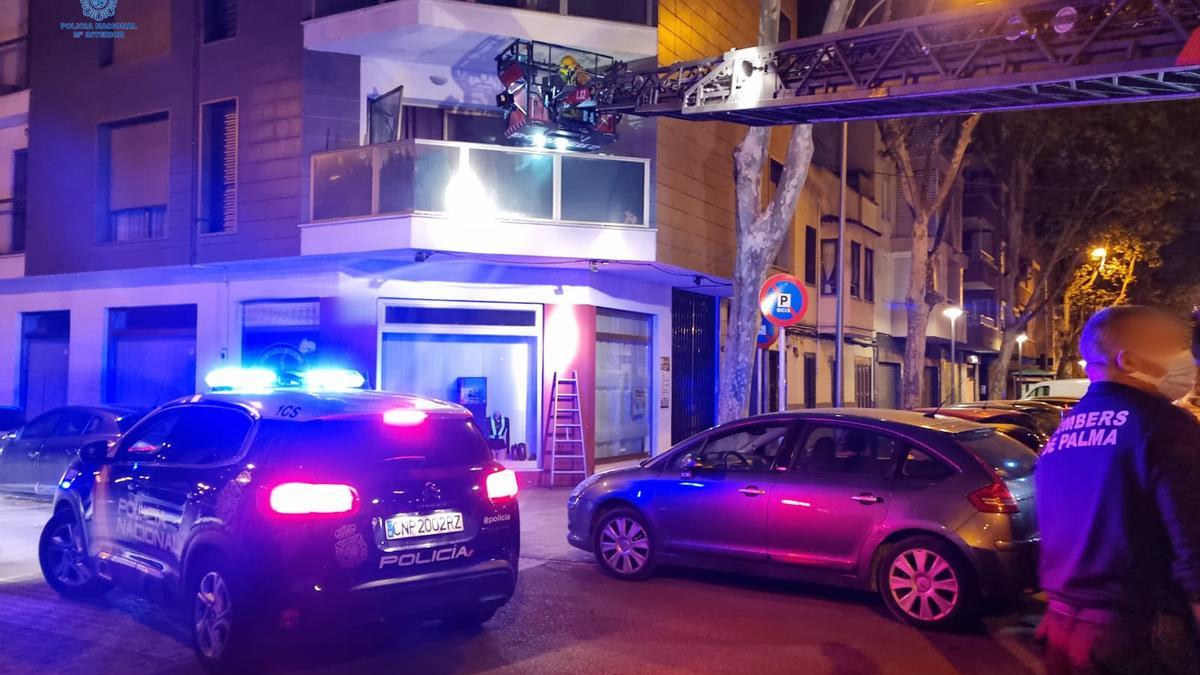 Policías entran en el piso desvalijado en la autoescalera de los bomberos.