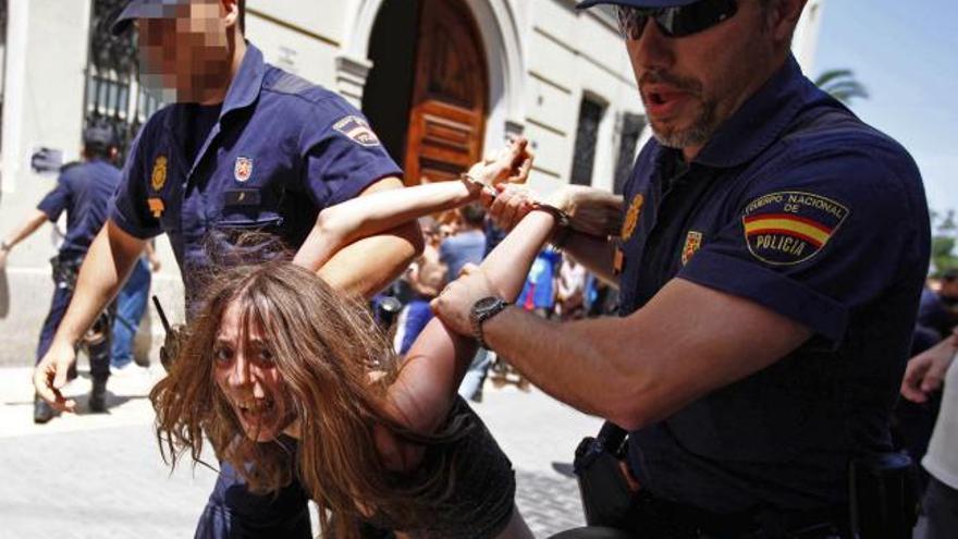 Agentes de la Policía Nacional se llevan detenida a una joven del movimiento 15-M, hoy en Valencia.