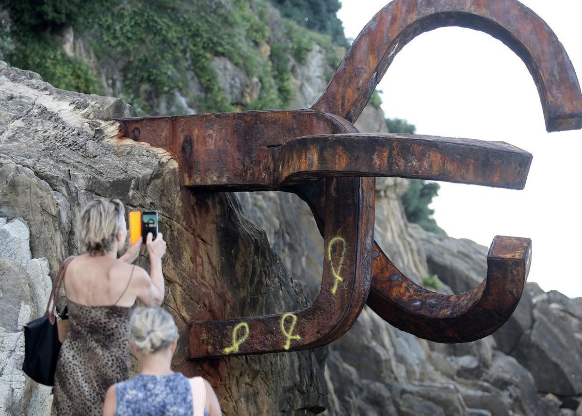 GRAFCAV7703. SAN SEBASTIÁN (GIPUZKOA), 04/09/2019.-Tres lazos amarillos, símbolo de la exigencia de libertad para los políticos catalanes encarcelados, han aparecido este jueves pintados en una de las tres esculturas de hierro que componen la emblemática obra del Peine del Viento, de Eduardo Chillida, en San Sebastián. EFE/ Gorka Estrada