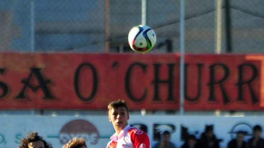 Eloy disputa un balón aéreo rodeado de jugadores del Galicia de Mugardos. // Iñaki Abella