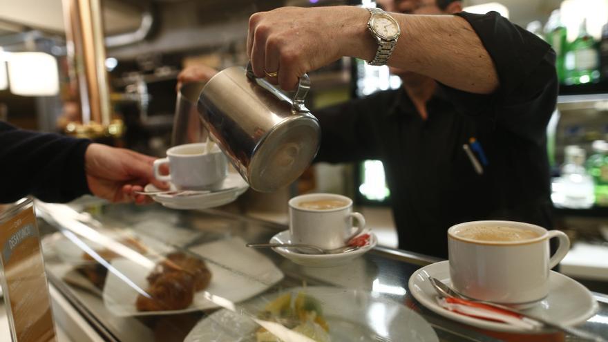 Un camarero sirviendo cafés.