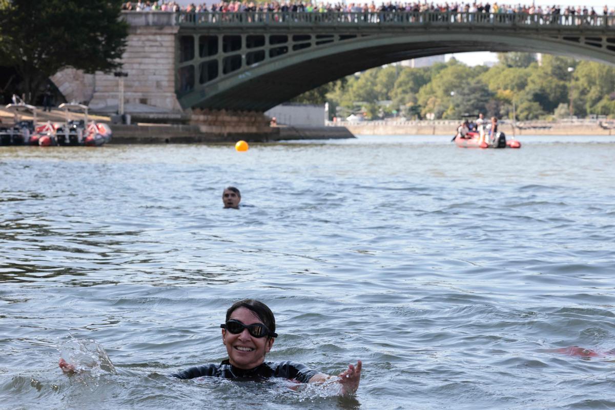 TOPSHOT - Paris Mayor Anne Hidalgo swims in the Seine, in Paris on July 17, 2024, to demonstrate that the river is clean enough to host the outdoor swimming events at the Paris Olympics later this month. Despite an investment of 1.4 billion euros ($1.5 billion) to prevent sewage leaks into the waterway, the Seine has been causing suspense in the run-up to the opening of the Paris Games on July 26 after repeatedly failing water quality tests. But since the beginning of July, with heavy rains finally giving way to sunnier weather, samples have shown the river to be ready for the open-water swimming and triathlon -- and for 65-year-old Hidalgo. (Photo by JOEL SAGET / POOL / AFP)