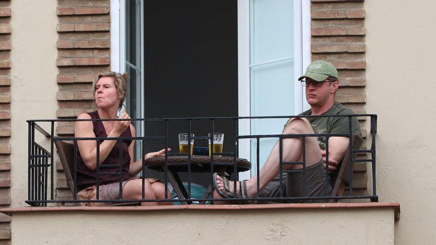 Dos turistas en la terraza de una vivienda.