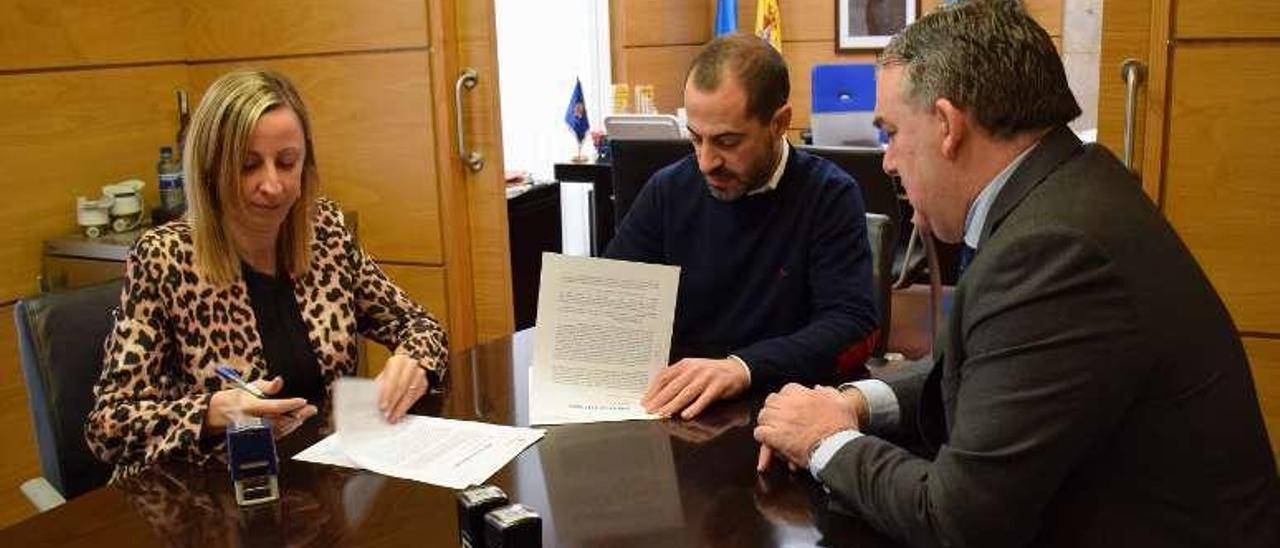 Vanessa Álvarez, directora de la oficina principal de Caja Rural en Pola de Siero; el alcalde, Ángel García, y Felipe Fanjul, secretario, en la firma.