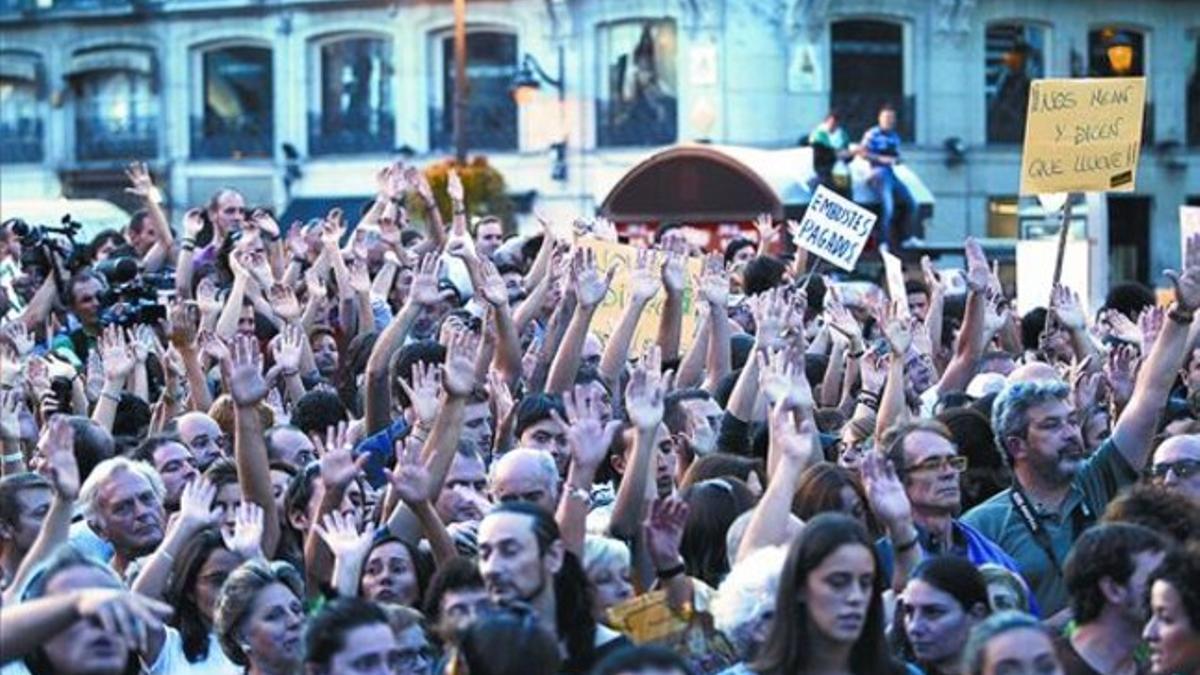 Decenas de personas levantan sus manos durante la manifestación en Madrid.